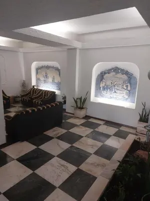 a living room with a couch and a checkered floor at Apartamento Quarteira T1 in Quarteira