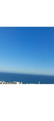 a view of the ocean from the balcony of a building at Apartamento Quarteira T1 in Quarteira