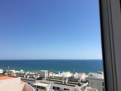 a view of the ocean from a building at Apartamento Quarteira T1 in Quarteira