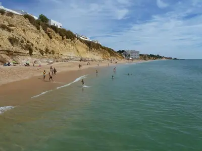 a group of people playing in the water on a beach at Holiday House in Albufeira
