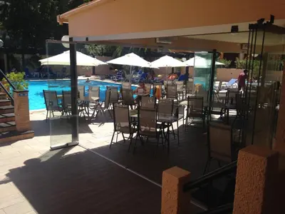 a patio with tables and chairs next to a swimming pool at Casa Balaia in Albufeira
