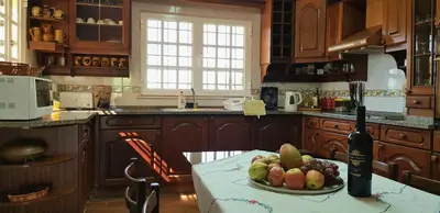 a kitchen with a plate of fruit and a bottle of wine at Villa Quinta da Violeta in Loulé