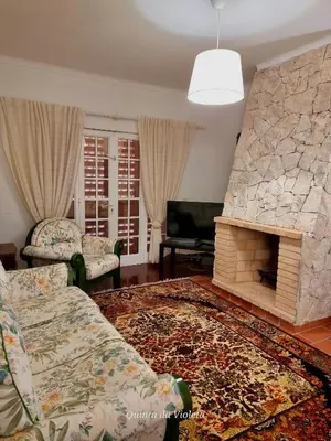 a living room with a couch and a stone fireplace at Villa Quinta da Violeta in Loulé