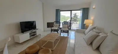 a living room with a couch and a table and chairs at Quinta do Lago Beach House in Quinta do Lago