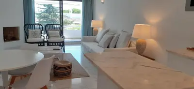 a living room with a white couch and a table at Quinta do Lago Beach House in Quinta do Lago