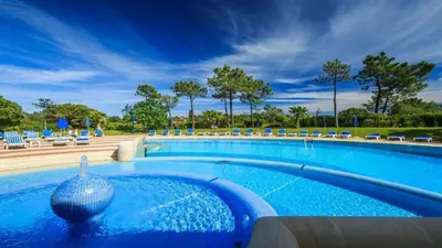 a large swimming pool with a vase in the middle at Quinta do Lago Beach House in Quinta do Lago