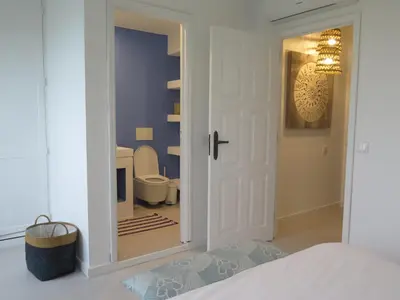 a bedroom with a door leading to a bathroom at T4 Grand Townhouse Old Village in Vilamoura