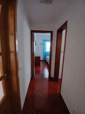 a hallway with two doors and a mirror at casa de ferias in Algoz