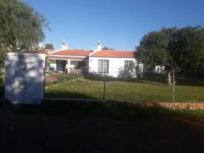 a white house with a fence in the yard at casa de ferias in Algoz