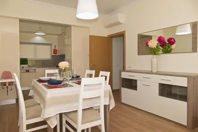 a kitchen and dining room with a table and chairs at Apartamento luxo e sossego in Albufeira