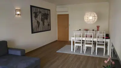 a living room with a dining room table and chairs at Apartamento luxo e sossego in Albufeira
