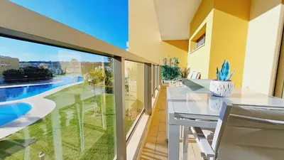 a balcony with a table and a view of a pool at Apartamento luxo e sossego in Albufeira