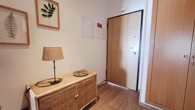 a room with a table with a lamp and a door at Apartamento luxo e sossego in Albufeira