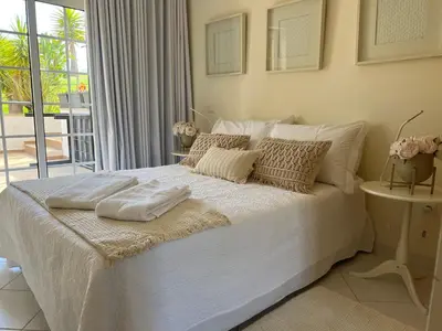 a white bed with two towels on it in a bedroom at Condominio Cerro da Guia in Guia