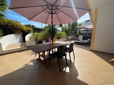 a table and chairs with an umbrella on a patio at Condominio Cerro da Guia in Guia