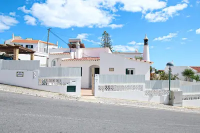 a white house with a white fence and a street at Villa Tibouchina in Albufeira