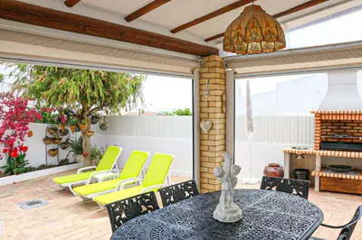 a patio with a table and chairs and a chandelier at Villa Tibouchina in Albufeira