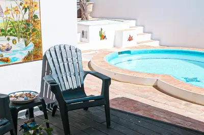 a pair of chairs sitting next to a swimming pool at Villa Tibouchina in Albufeira