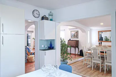 a kitchen and dining room with a white refrigerator at Villa Tibouchina in Albufeira