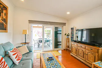 a living room with a couch and a flat screen tv at Villa Tibouchina in Albufeira