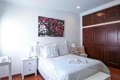 a bedroom with a bed and a painting on the wall at Villa Tibouchina in Albufeira