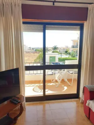 a living room with a view of a balcony at Apartment on The Strip Albufeira in Albufeira
