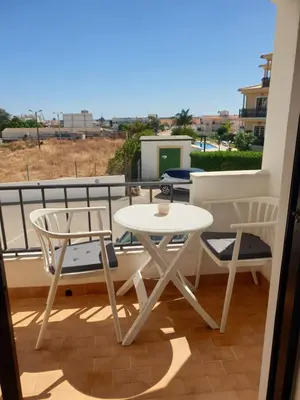 a table and two chairs on a balcony at Apartment on The Strip Albufeira in Albufeira