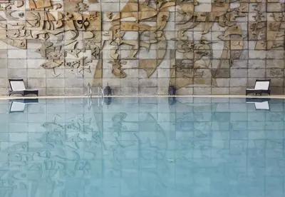 a swimming pool with graffiti on a wall at Crowne Plaza Vilamoura - Algarve by IHG in Vilamoura