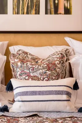 a pile of pillows sitting on top of a bed at Birdsong Vila Sol Village in Vilamoura