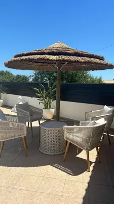 a group of chairs and an umbrella on a patio at Cegonha Villa powered by Cegonha Resort- Private swimming pool & air con in Albufeira