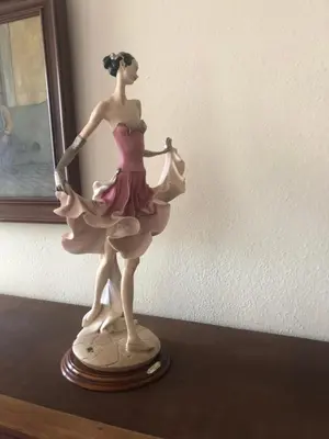 a figurine of a woman in a pink dress on a table at Maria Guest house in Albufeira