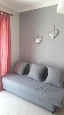 a couch in a room with two hearts on the wall at Ritta's house in Albufeira