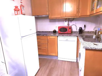 a kitchen with a white refrigerator and a sink at Ritta's house in Albufeira