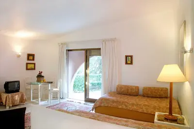 a bedroom with a bed and a table and a window at Lageado Park in Albufeira