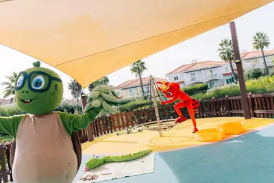 a person standing in front of a playground at Eden Villas & Apartments in Albufeira