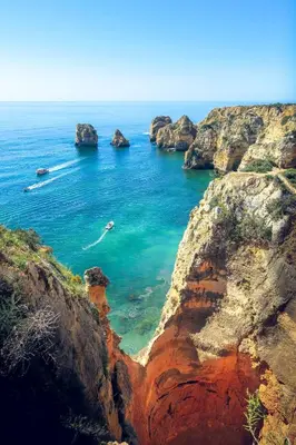 a boat in a body of water between two rocks at Smy Santa Eulalia Algarve in Albufeira