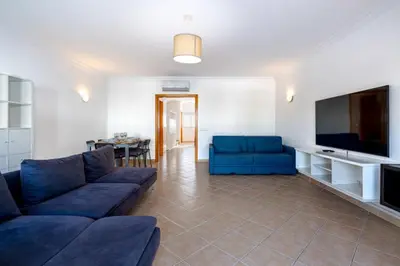 a living room with two blue couches and a television at Smy Santa Eulalia Algarve in Albufeira
