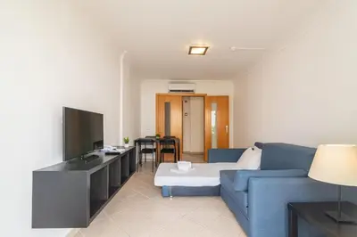 a living room with a blue couch and a television at Smy Santa Eulalia Algarve in Albufeira