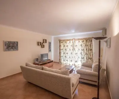 a living room with a couch and a tv at Casa das Flores in Vale do Lobo