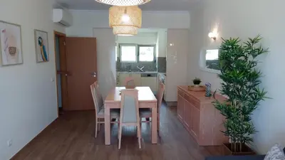 a kitchen and dining room with a table and chairs at Apartamento O Jardins da Marina in Albufeira