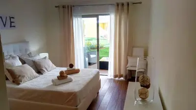 a bedroom with a bed and a sliding glass door at Apartamento O Jardins da Marina in Albufeira