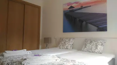 a room with a white couch with a picture on the wall at Apartamento O Jardins da Marina in Albufeira