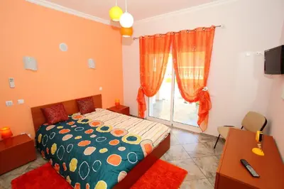 a bedroom with a bed and a desk and a window at Vivenda Luz - Jacuzzi & Swimming Pool in Albufeira