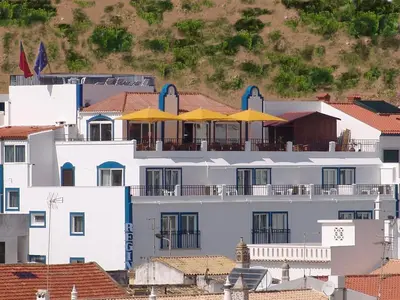 a white building with yellow umbrellas on top of it at Apartamentos Turisticos Regina in Albufeira