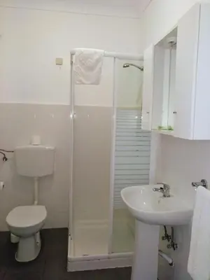 a bathroom with a shower and a toilet and a sink at Apartamentos Turisticos Regina in Albufeira