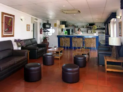 a waiting room with couches and tables and a bar at Apartamentos Turisticos Regina in Albufeira