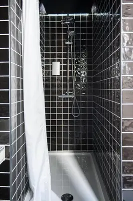 a black tiled bathroom with a tub and a shower at Lemon Tree Stay in Faro