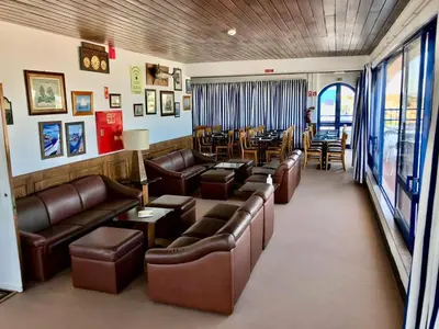 a living room with leather couches and a dining room at Hotel da Gale in Albufeira