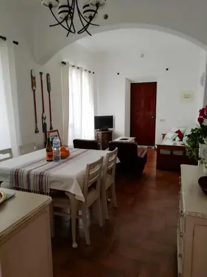 a dining room with a table and a living room at Casa da Guida in Albufeira