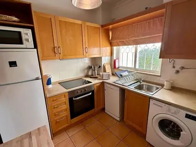 a kitchen with a white refrigerator and a dishwasher at Monteverde Kulle by FHR piscina & parking in Vilamoura